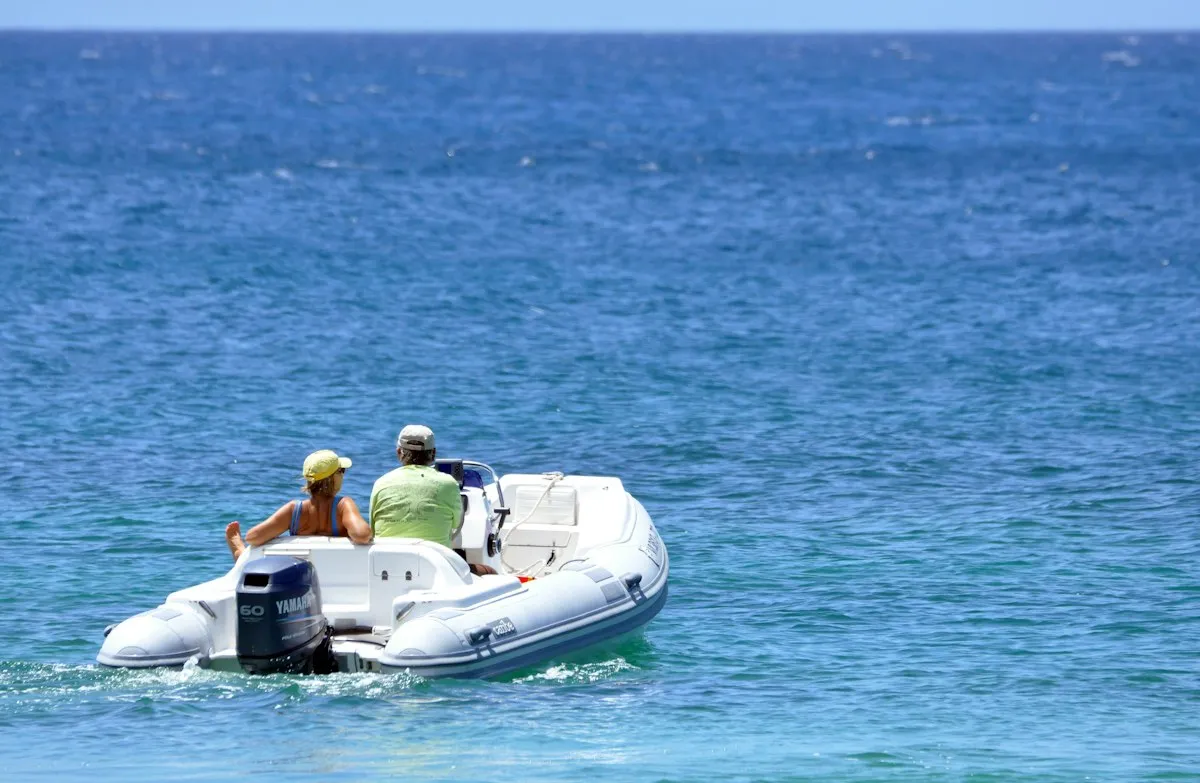 Annexe gonflable avec deux passagers traversant une baie