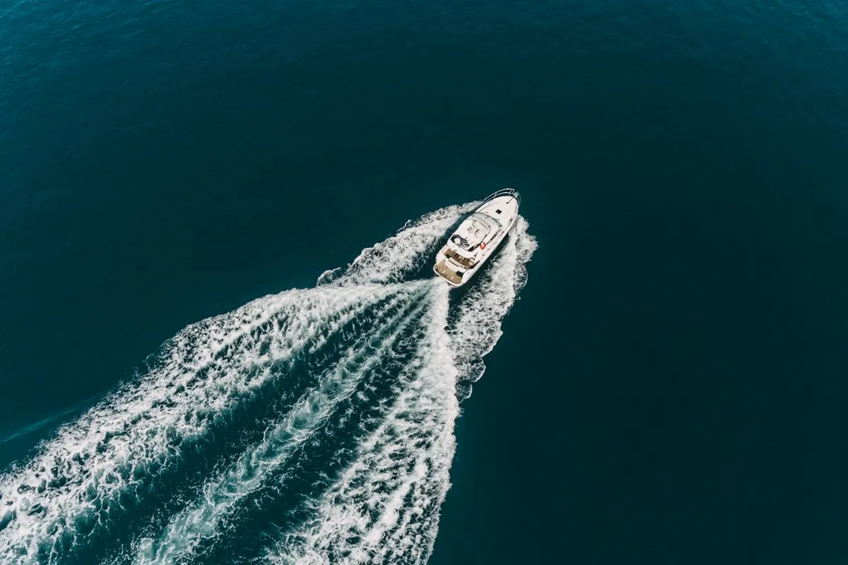 Vue aérienne d'un bateau sportif filant sur une mer bleu profond