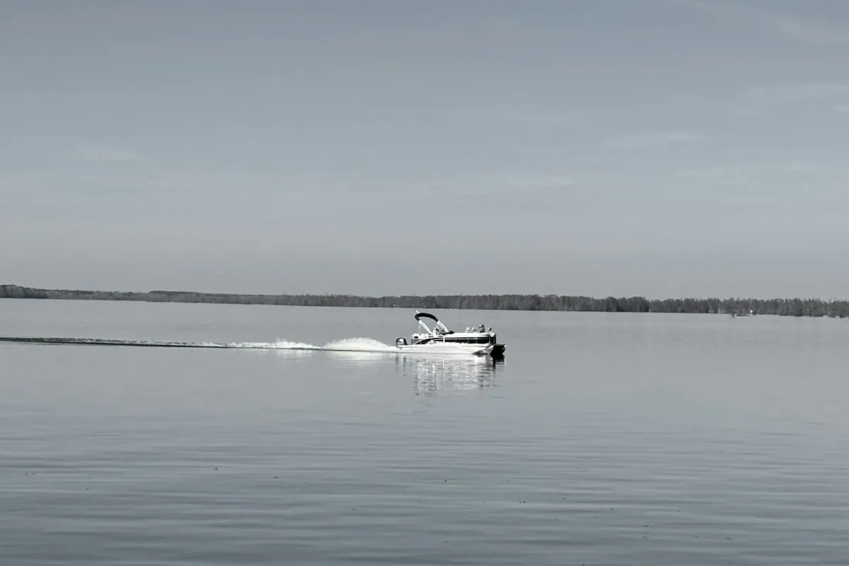 Bateau ponton traçant son sillage sur un lac calme