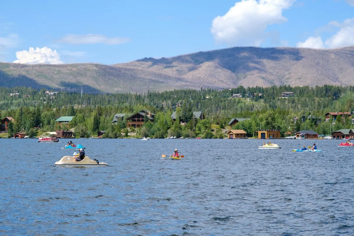 Pédalos et kayaks sur un lac entouré de montagnes