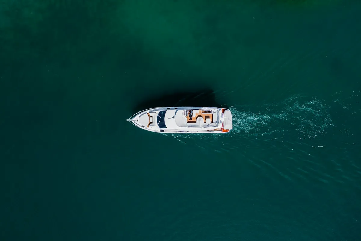 Vue aérienne d'un bateau à moteur de croisière côtière filant sur une mer sombre