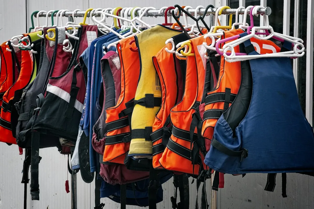 Plusieurs modèles de gilets de sauvetage suspendus côte à côte