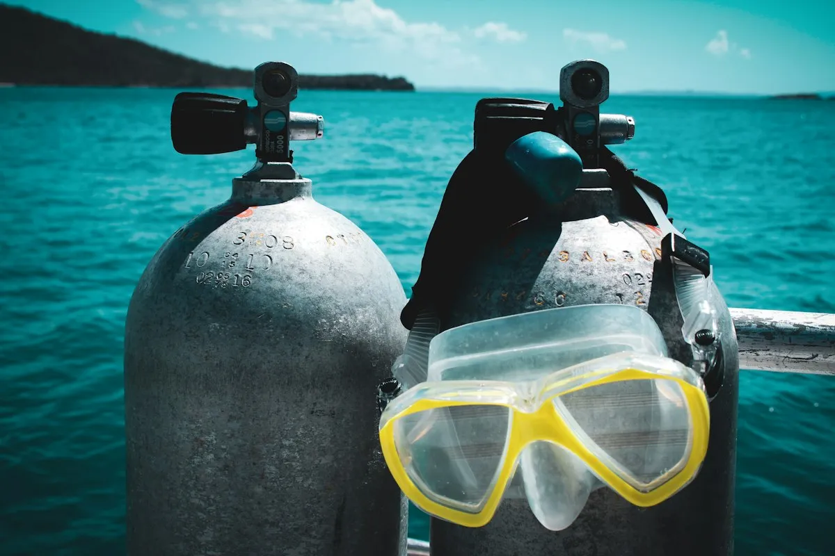 Bouteilles et masques de plongée posés sur le bastingage d'un bateau