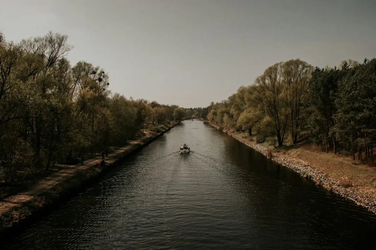 Petit bateau naviguant sur une rivière bordée de forêt