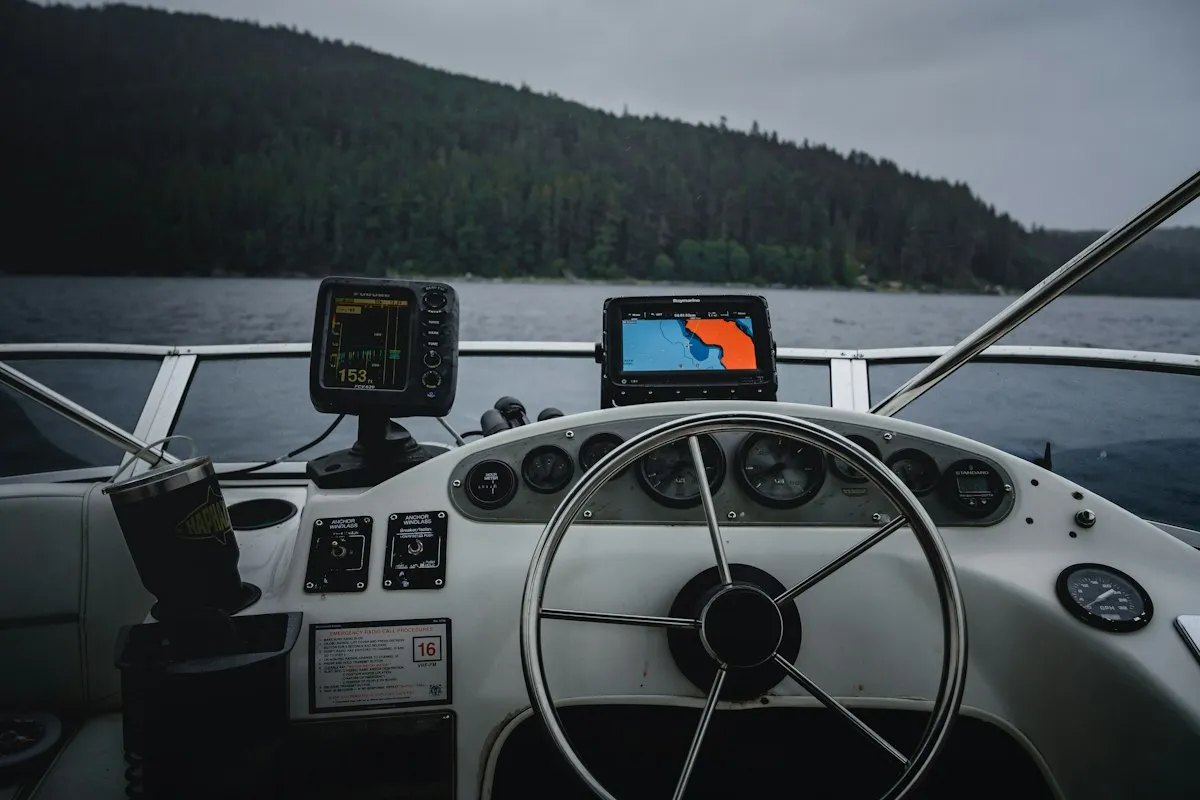 Poste de pilotage avec sondeur et traceur GPS, lac entouré de montagnes