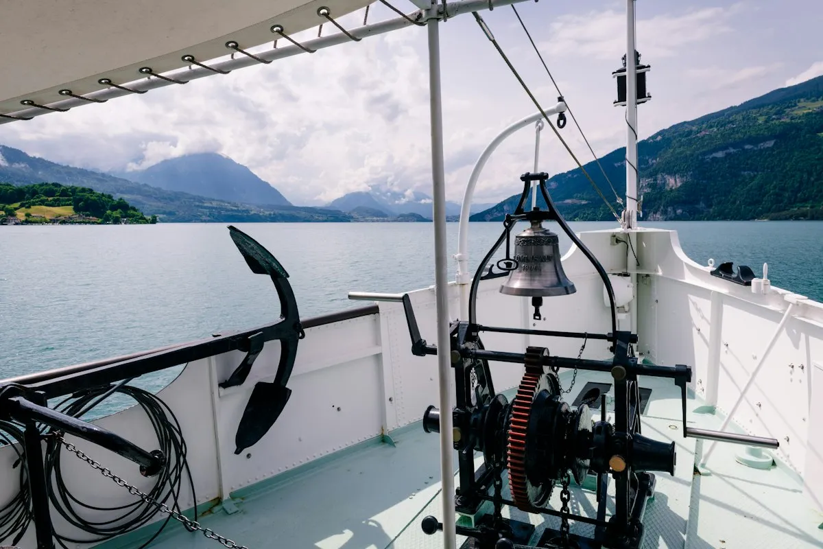 Guindeau manuel et ancre sur le pont d'un bateau, lac de montagne en arrière-plan