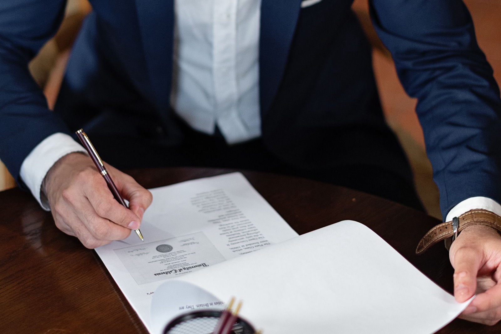 Personne signant des documents administratifs sur un bureau