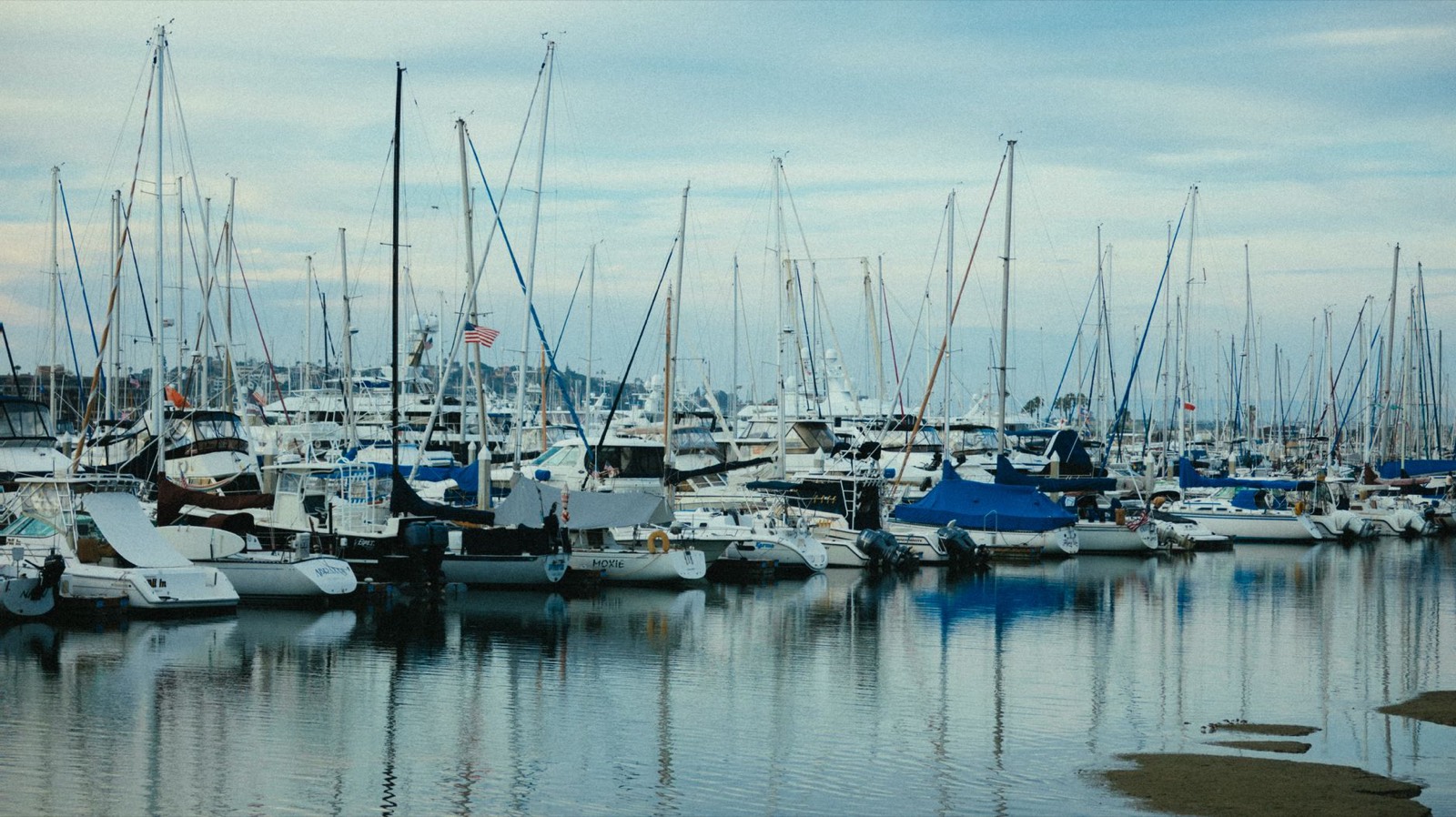 Voiliers amarrés dans un port devant un bureau de location de bateaux